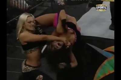 Aksana stretching AJ Lee around the ring post in FCW 