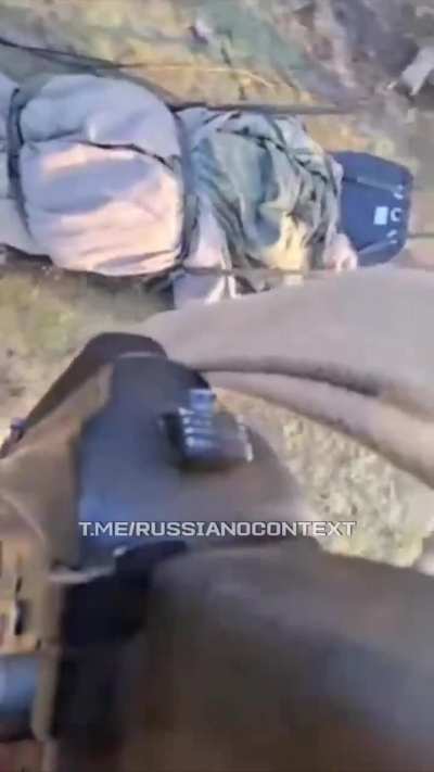 Russian soldiers pull a wounded comrade behind them