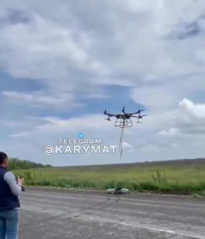 A large Ukrainian drone pulls out the wreckage of a downed Russian Orlan-10 UAV that fell in a minefield