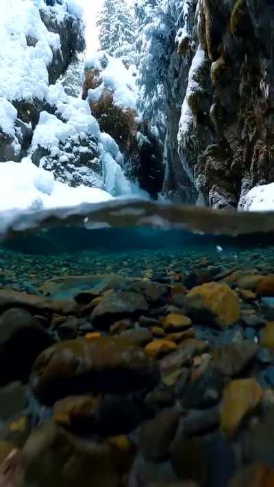 🔥 Snow falling on crystal clear Alaskan glacial melt water. Credit: Photographer John Derting