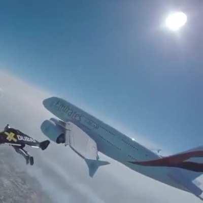 The Swiss Yves Rossi flying with a jetpack at the altitude of 1.2km and at the speed of 315 km/h beside an airplane.