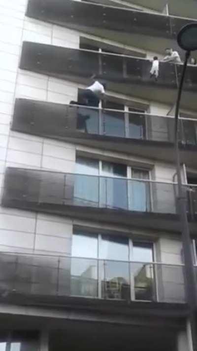 Man scales building to save dangling child