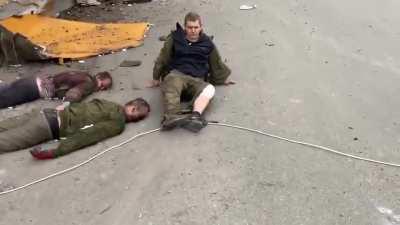 Russian POW under fire pulled to the side for questioning by Ukrainian fighters.