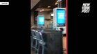 A woman throws a milkshake over the counter at a McDonald's worker