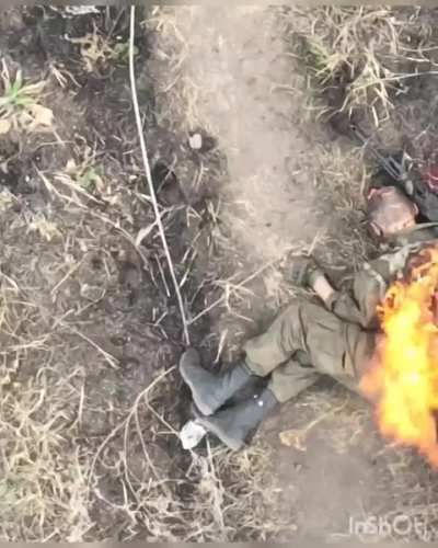 A RF fighter attempt to save his dead compatriot's backpack, himself catches fire, gives up.