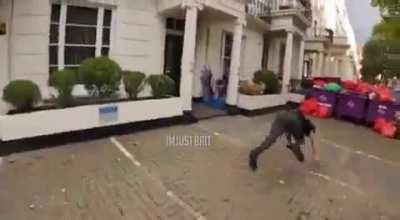 A person in the UK tripping over a fleeing suspect to help police capture him.