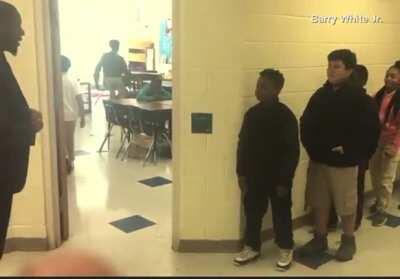 Fifth grade English teacher Barry White Jr., doing a personalized handshake with every one of his students before class.