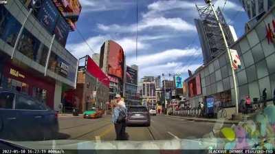 Couple think they are in slowmo in a romantic movie kissing in the middle of the road on a green light.