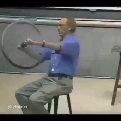 Physics professor demonstrating conservation of angular momentum