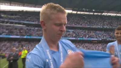 Oleksandr Zinchenko with the Premier League trophy, supported by his Manchester City teammates as he sheds a tear for Ukraine