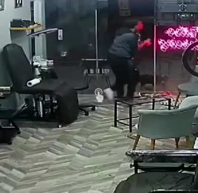 Guy charges a man with a shotgun in a tattoo parlor