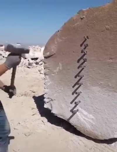 Just a dude perfectly splitting a giant rock in half