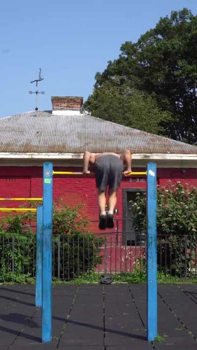 A man doing pull ups in reverse.