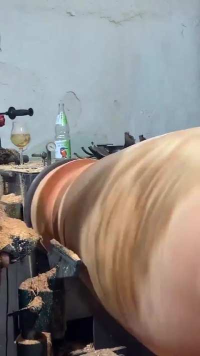 Wood turning a log into a textured vase.