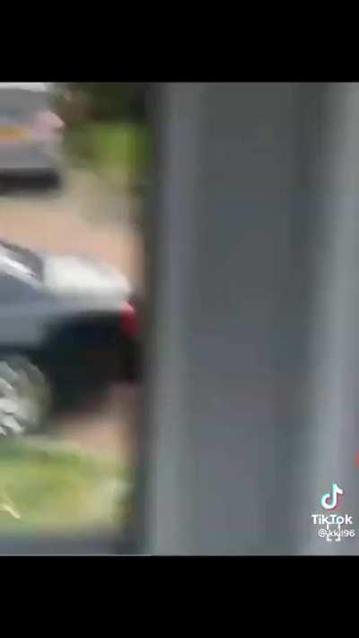 Homeless man rakes yard with nice car out front