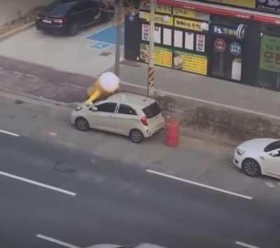 Balloon sign seen diligently hand washing a car.