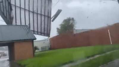 Hurricane Ida ripping apart a roof of a building.