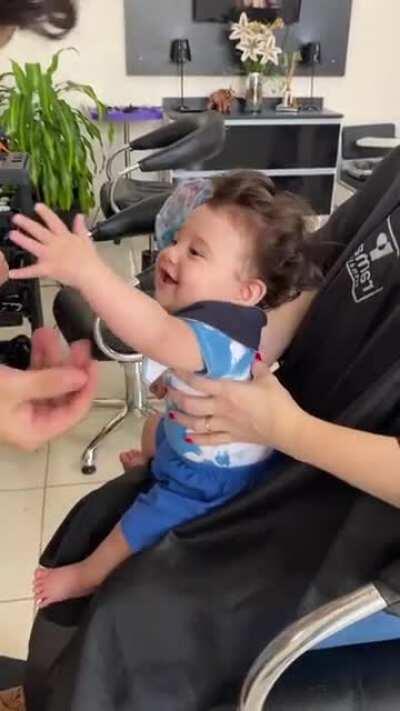 A 6 month old kid loving his first haircut