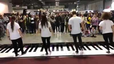 Dancers playing The Pirates of the Caribbean theme song on a giant piano