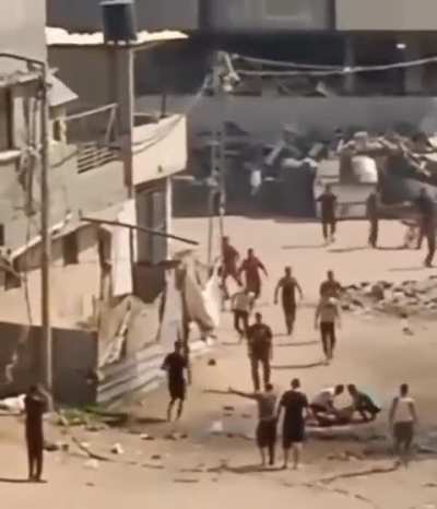 Palestinian Child injured in the middle of the street. Civilians gather to try to help, Israel airstrikes the civilians