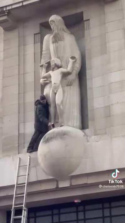 Guy climbs onto the BBC building and attempts to smash up the Eric Gill pedophile statue