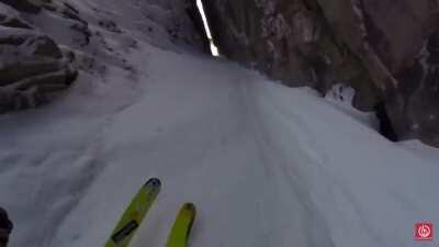 Dude skis through tiny crack in a mountain