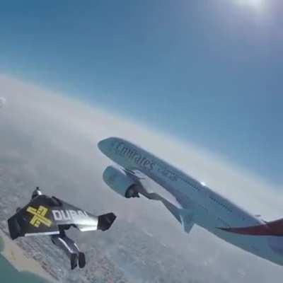 Man with a jetpack, flying next to a plane