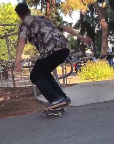 Kick flipping a skateboard through a guard rail