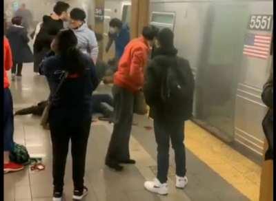 An interesting video from the subway mass shooting. Initially, there is no blood on the ground as the injured person limps away from the train. Then blood appears after someone in a red hoodie walks by, who seems to be pouring something on the ground...