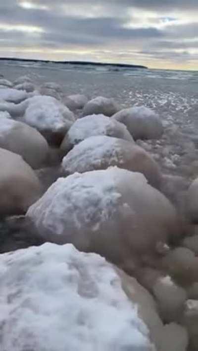 Ice balls form due to gentle rocking of waves in below freezing temperatures