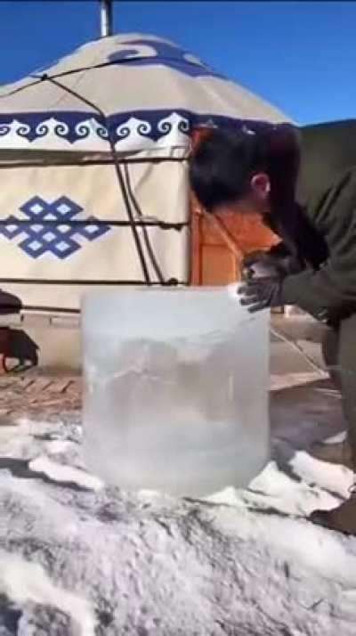 A man turning ice into a freezer.