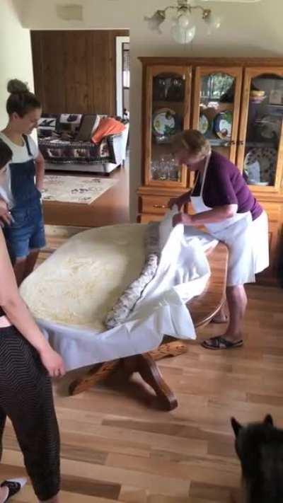 Grandma showing her grandchildren how to roll giant strudel.