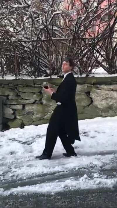 This guy sliding down an Icy hill while wearing a tux and holding a glass of Wine