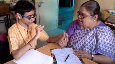 Deafblind student taking his test with the help of braille and sign language.