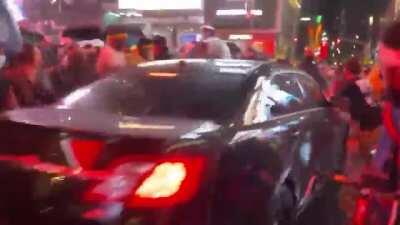 Car drives through protestors in Times Square.