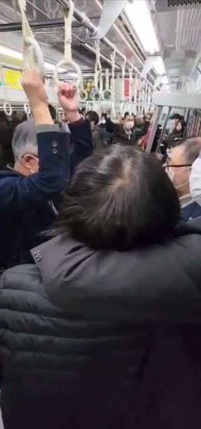 Two men fighting quietly in Japan so they don’t disturb others in the subway