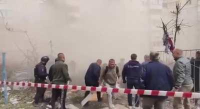 Onlookers scatter as more of the Belograd building collapses during rescue efforts. 