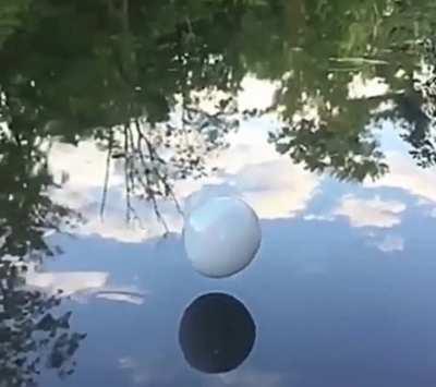 Smoke filled bubbles bouncing on water surface