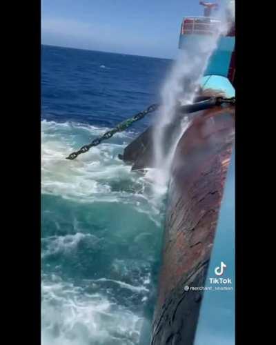 A giant anchor emerging from the ocean