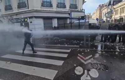 French Protester Takes Water Cannon to the Face Like an Absolute Boss