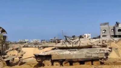 Partially destroyed Merkava being towed by a bulldozer 