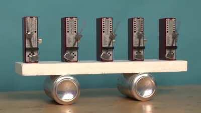 Metronomes started randomly synchronize after a short period of time as they influence each other through the side-to-side motion of their shared base, a mechanical realization of the mathematical 