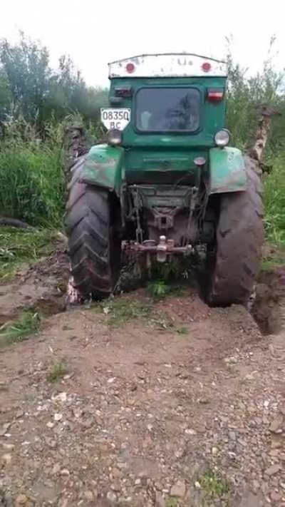 Using tree limbs chained to the wheels to free a stuck tractor