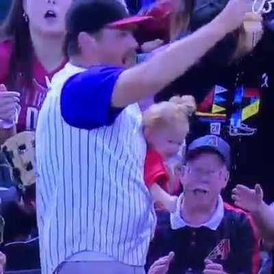 Father drops child momentarily to catch the ball