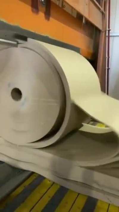 Cutting through a huge roll of paper