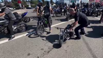 Man with a syringe tries to steal a mini-bike amongst a group of motorcyclists