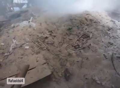 After his trench was attacked with a gas grenade, a Brazilian soldier of the International Legion throws sand over the grenade to try to stop the gas emission. Kreminna Forest, Luhansk Oblast. Probably October 2024