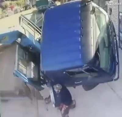 Idiot tries to stop truck from falling and nearly dies