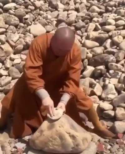 Monk breaks stones with his fingers