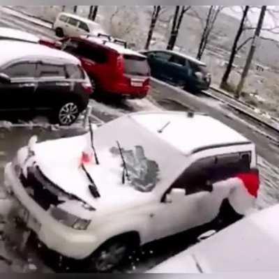 Huge debris chunk helps a guy to get rid of some snow on his car